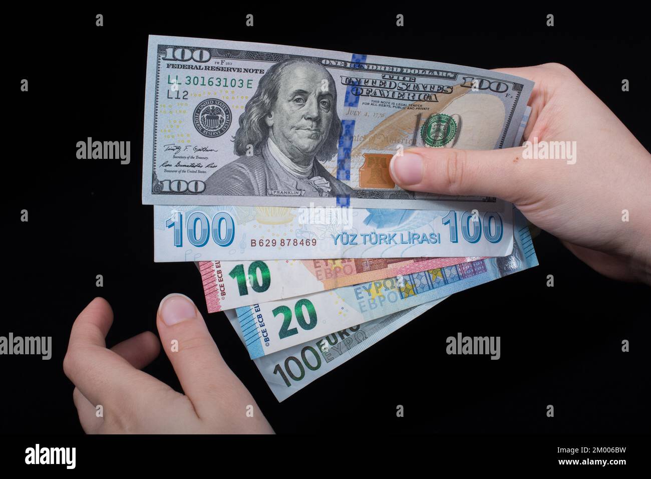 Tenere a mano le banconote in dollari americani isolate su sfondo nero Foto Stock