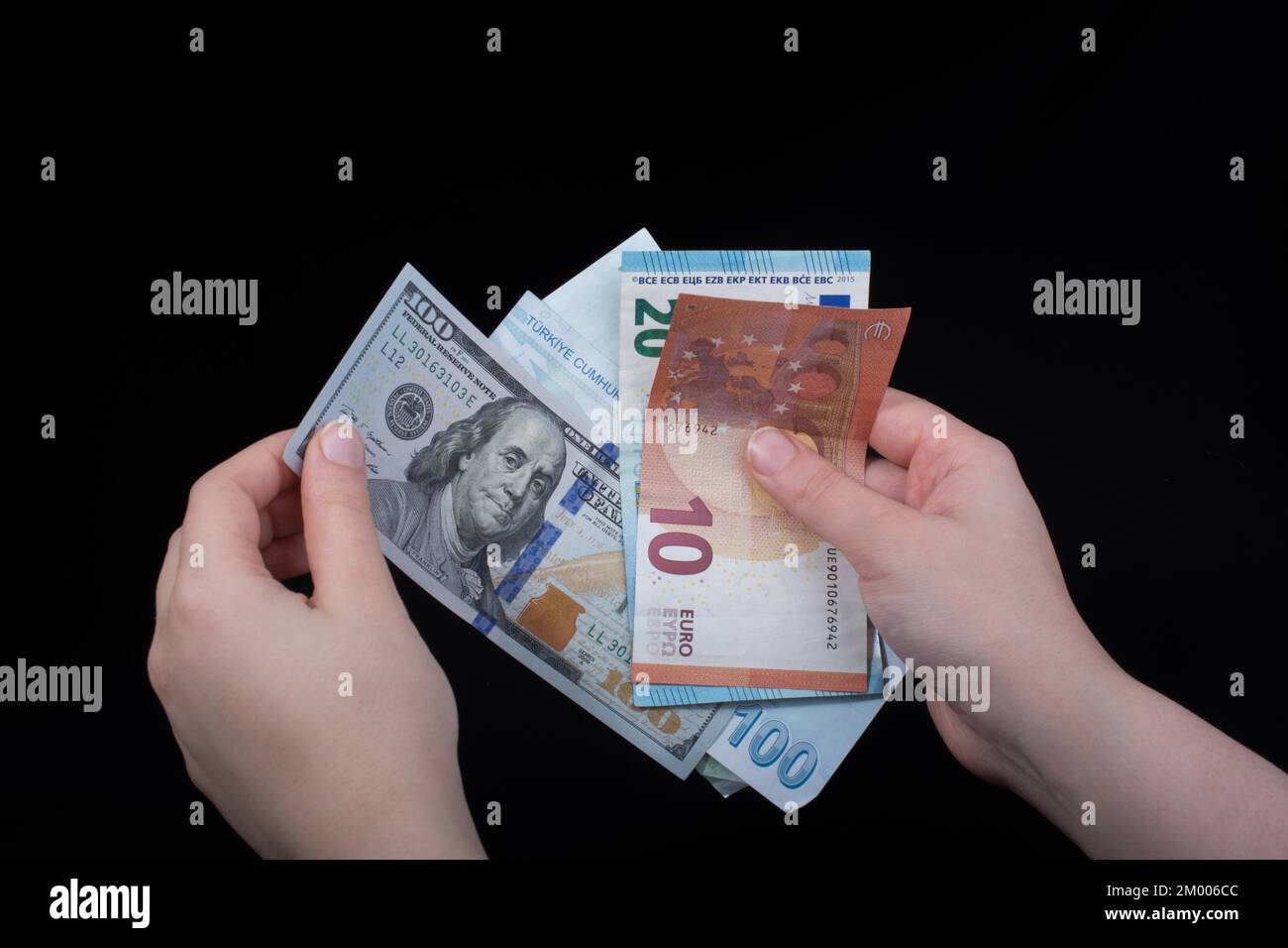 Tenere a mano le banconote in dollari americani isolate su sfondo nero Foto Stock