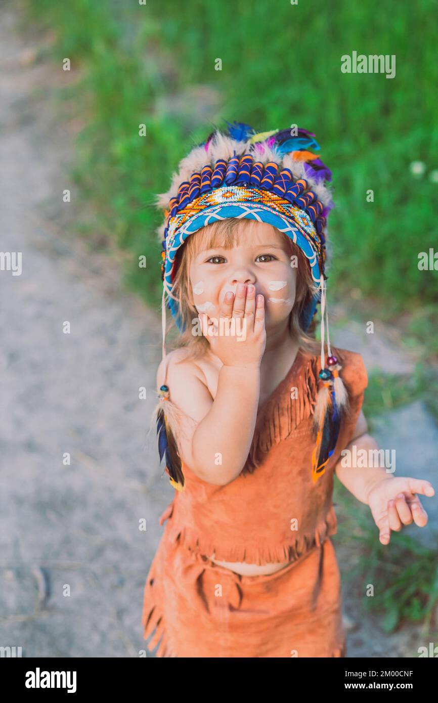 Adorabile bambino vestito come un nativo americano fa un grido di battaglia Foto Stock