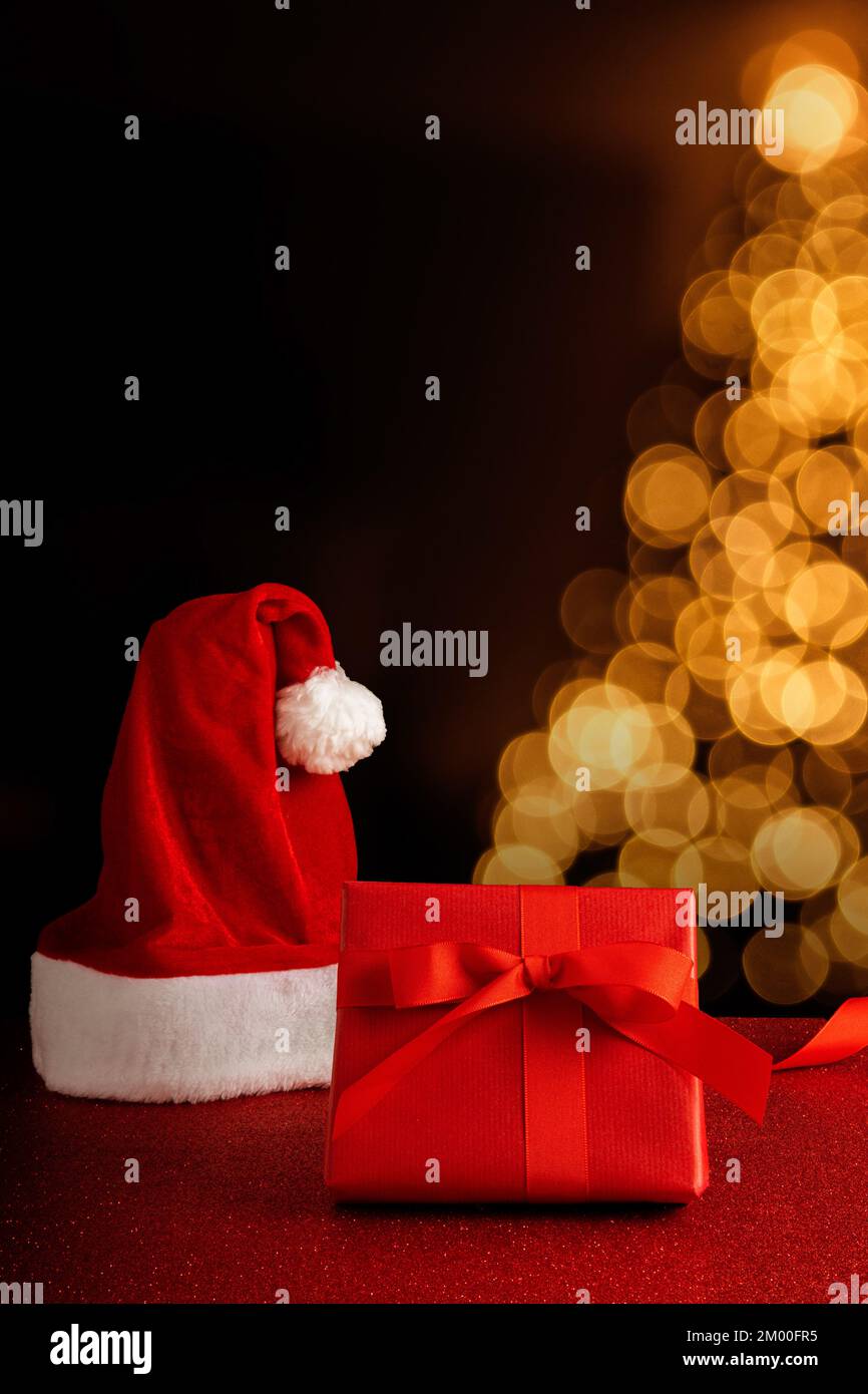 Sfondo di Natale con spazio copia nei colori rosso e nero su un albero di natale bokeh Foto Stock