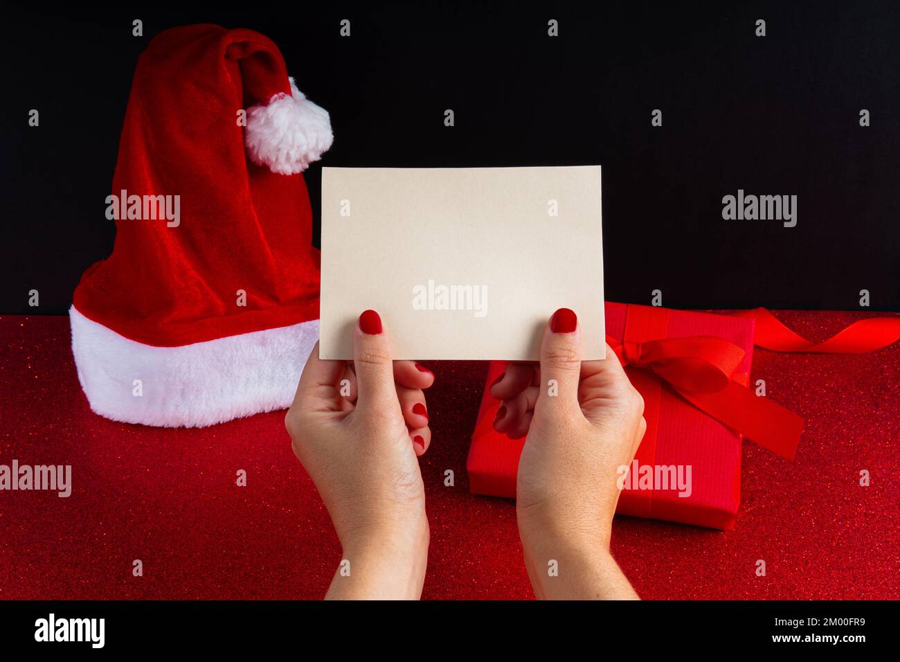 Cartolina mock in su con la mano della donna e sfondo di natale Foto Stock