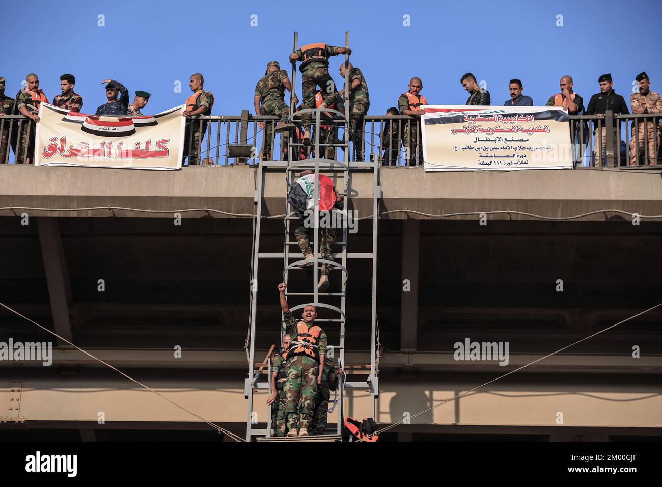 Baghdad, Iraq. 03rd Dec, 2022. I cadetti militari dell'Accademia militare irachena eseguono il salto di fiducia saltando dal Ponte Ramadan 14 nel fiume Tigri. Credit: Ameer al-Mohammedawi/dpa/Alamy Live News Foto Stock