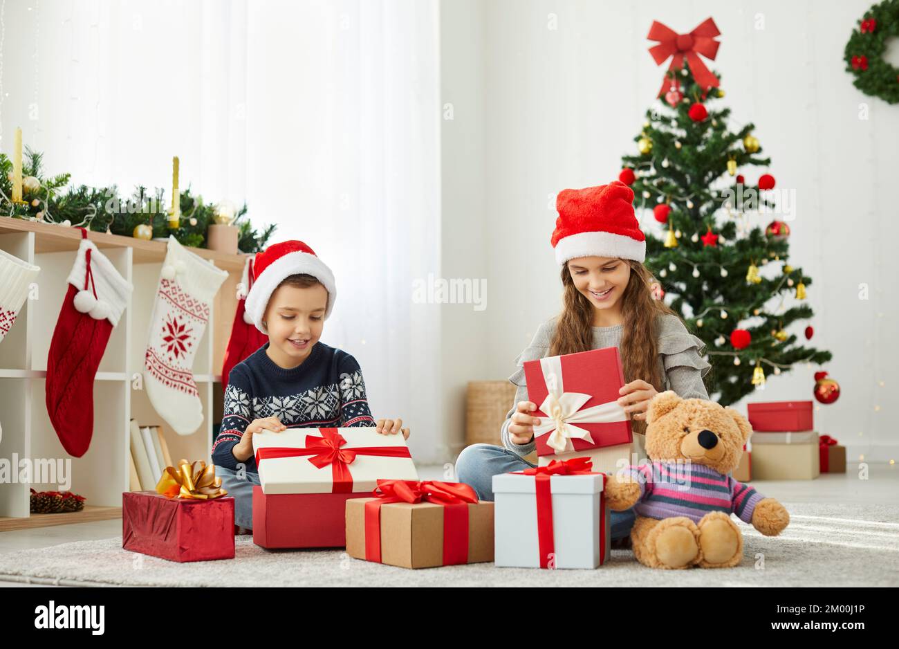 I bambini felici godono di disimballaggio regali di Natale Foto Stock