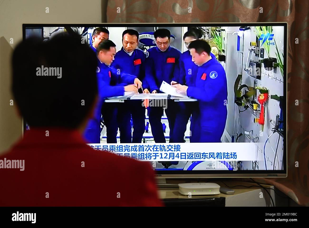 FUYANG, CINA - 3 DICEMBRE 2022 - i cittadini guardano le notizie televisive mostrando all'equipaggio dell'astronauta cinese di completare la prima consegna in orbita a Fuyang City, An Foto Stock