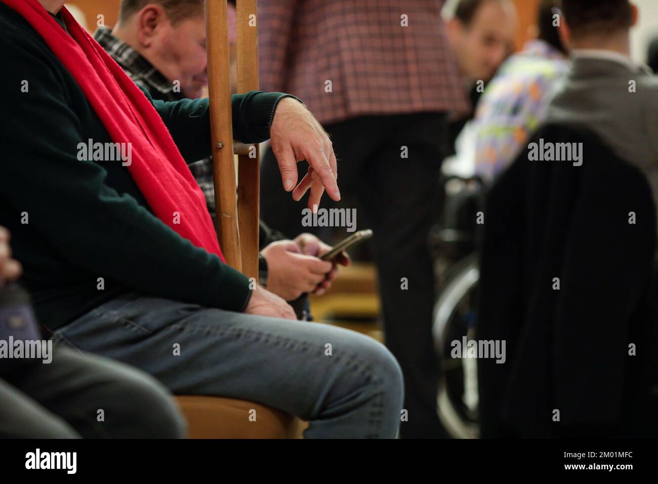 Profondità di campo bassa (messa a fuoco selettiva) dettagli con un uomo che utilizza stampelle. Foto Stock