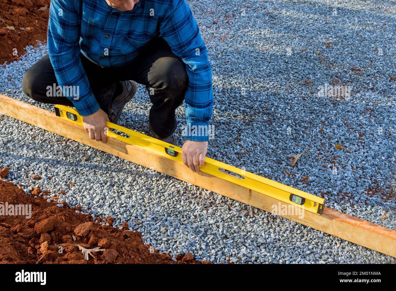 In cortile, c'è bisogno di creare una superficie piana per ghiaia da utilizzare come fondazione per capannone. Foto Stock