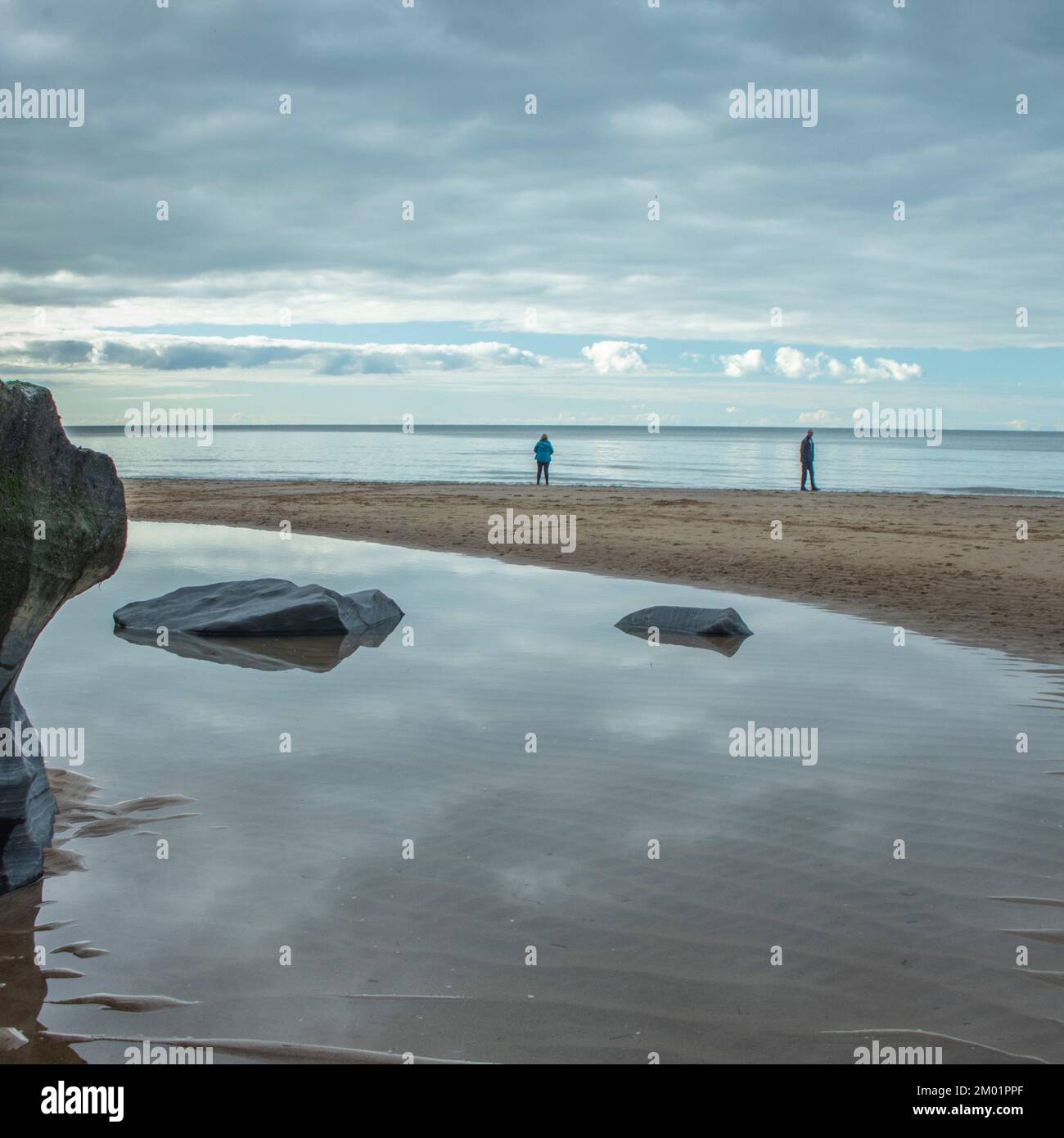 Foto a colori di pietre costiere sulla spiaggia levigata e arrotondata dai passaggi del tempo e della marea, contenenti pietre ciottoli ciottoli con grana Foto Stock
