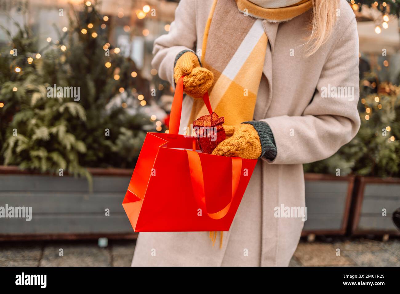 Elegante giovane bella donna felice passeggiata con borse per la spesa e scatole regalo in strada città. Allegro ragazza attraente shopper con sacchetti di carta e. Foto Stock