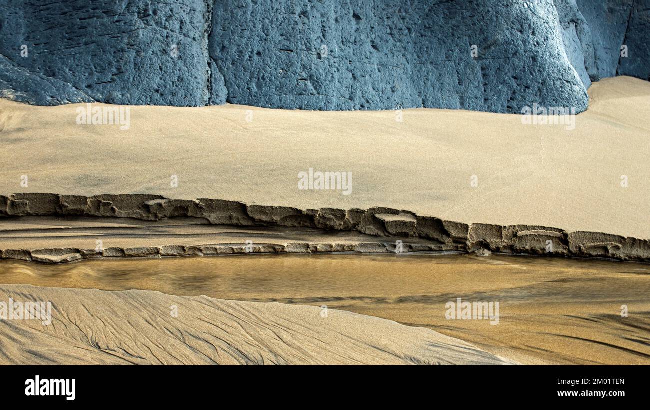 Realistica fotografia astratta a colori di rocce costiere e spiagge sabbiose scolpite dai passaggi del tempo e della marea con motivi e texture granulose Foto Stock