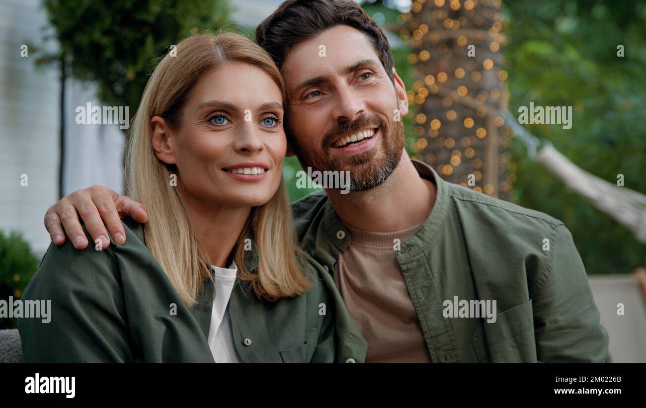 Coppia sposata amorevole marito e moglie uomo caucasico bearded e donna bionda 40s sposi sedersi all'aperto guardando in distanza sognando contemplare Foto Stock