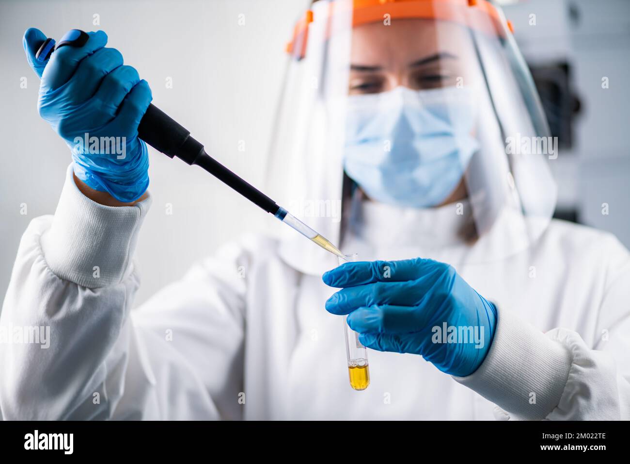 Un ricercatore che pipetta un campione pericoloso Foto Stock
