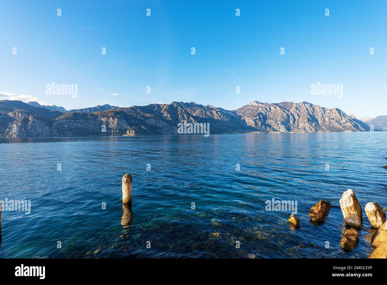 Lago di Garda (Lago di Garda) dal paese di Malcesine, Verona, con le Alpi italiane e il piccolo villaggio di Limone sul Garda. Veneto e Lombardia. Foto Stock
