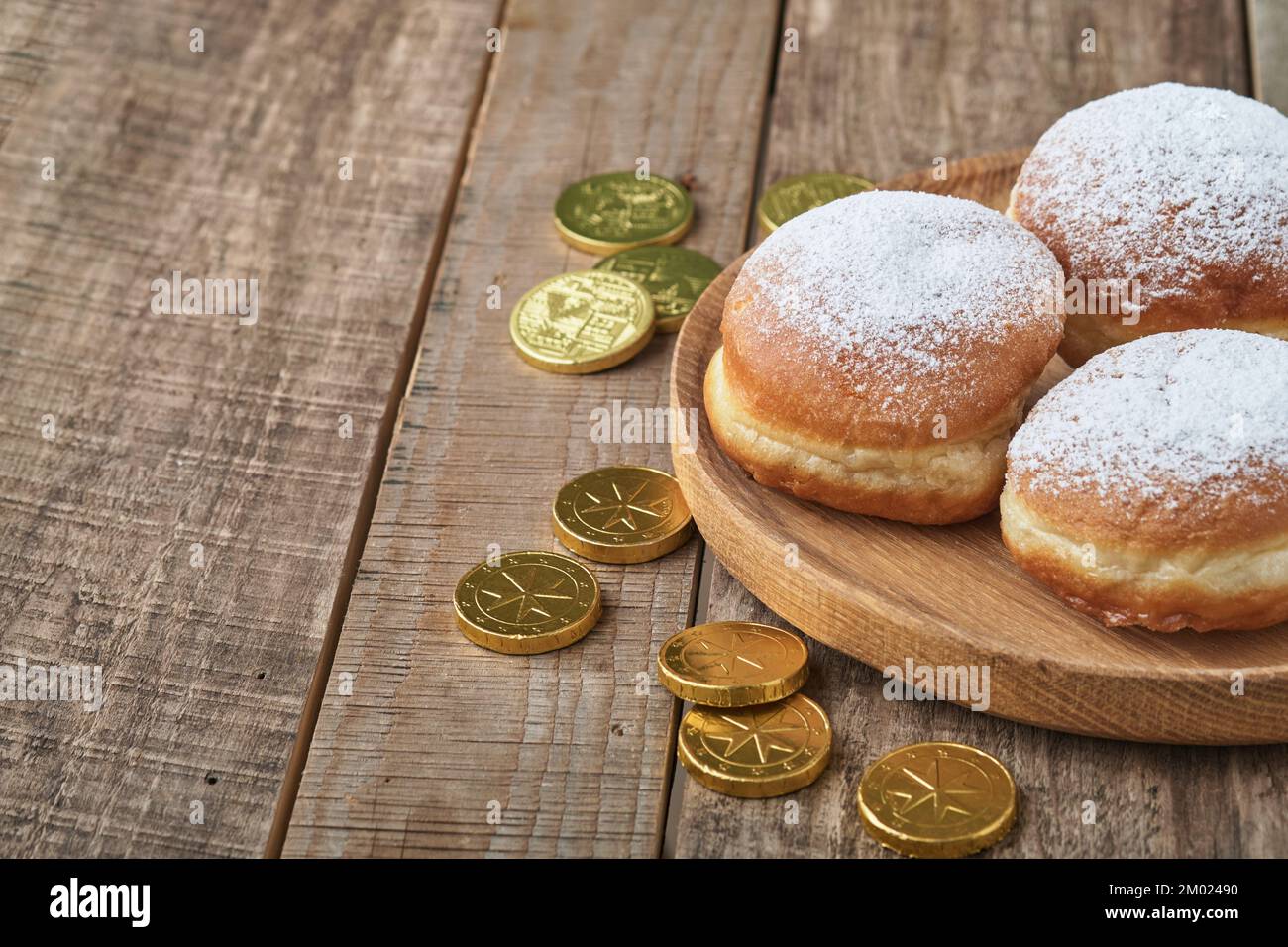 Hanukkah felice. Ciambelle dolci Hanukkah, scatole regalo, candele bianche e monete di cioccolato su vecchio sfondo di legno. Immagine e concetto di vacanza ebraica Foto Stock