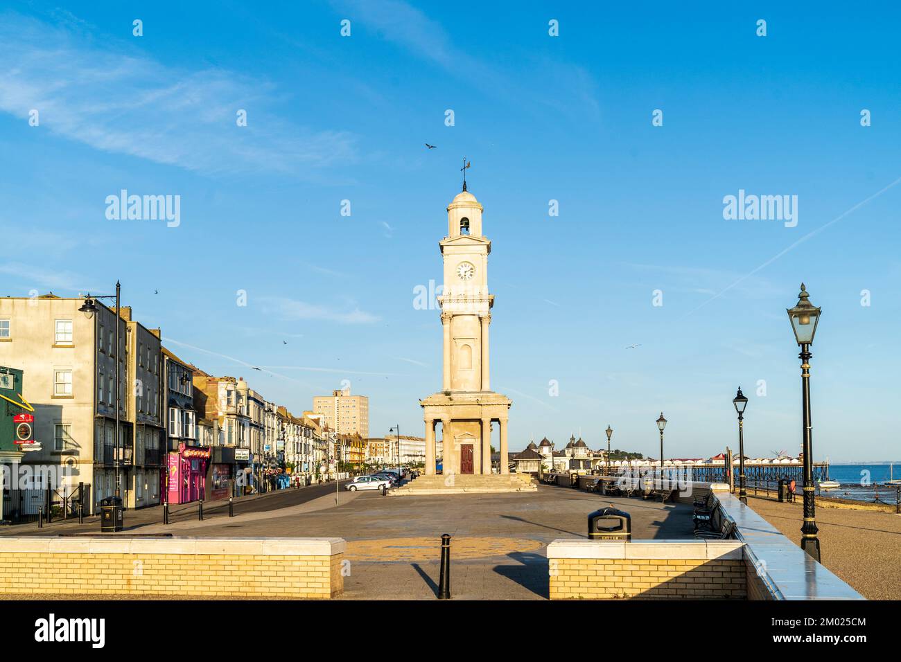 La parata centrale deserta, il lungomare e la torre dell'orologio sul lungomare di Herne Bay nel Kent, alle 6 di mattina d'estate sotto un cielo blu chiaro Foto Stock