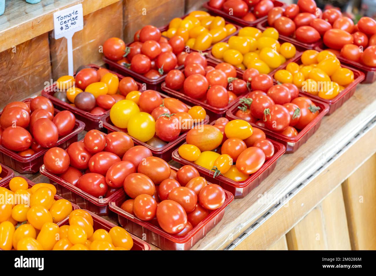 Pomodori ciliegini in contenitori di plastica, in vendita su un mercato estivo Foto Stock Pomodori ciliegini in contenitori di plastica, in vendita su un mercato estivo Foto Stock