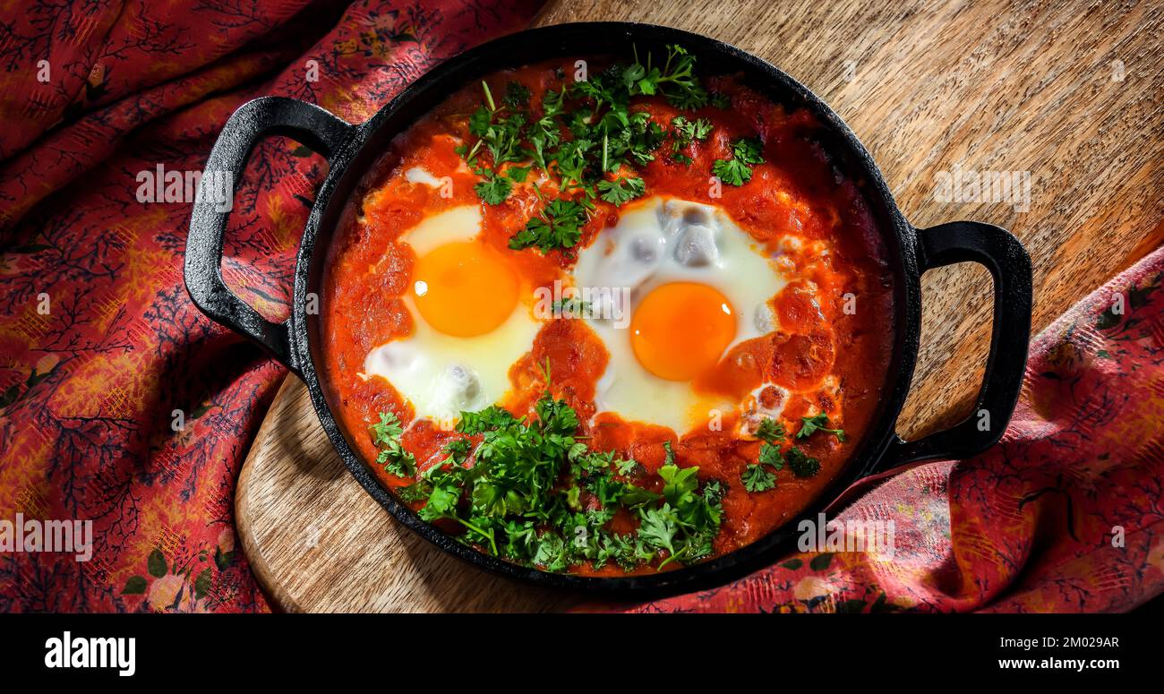 Piatto shakshouka in una padella di ghisa. Foto Stock