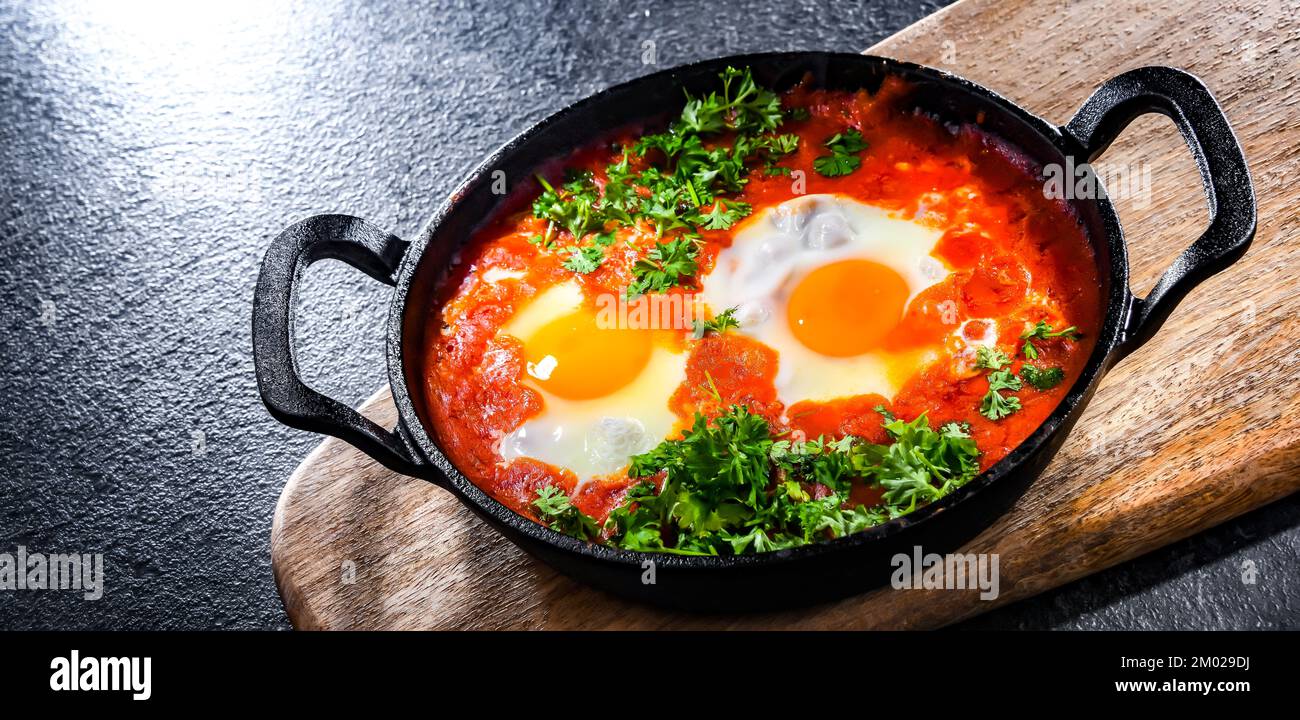 Piatto shakshouka in una padella di ghisa. Foto Stock