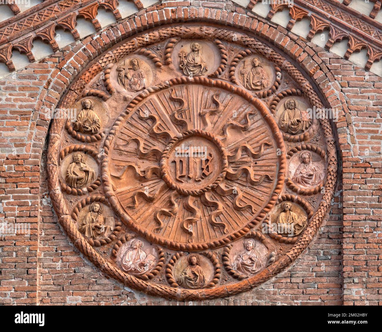 Rosoni centrali con il monogramma Cristo IHS e i dodici apostoli sulla facciata della Chiesa di Santo Stefano, Ferrara Italia Foto Stock