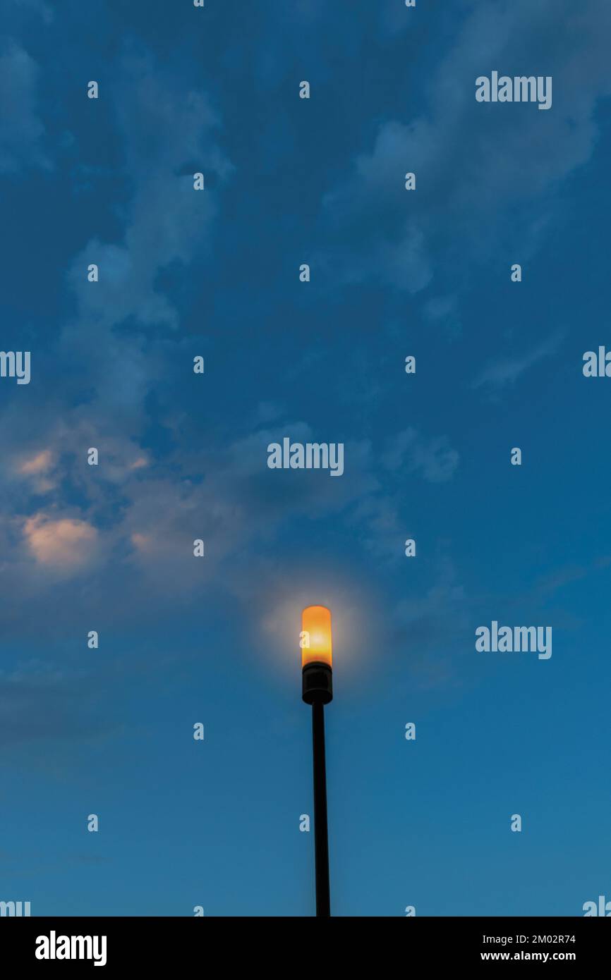 Lampione illuminato contro il cielo crepuscolo. Foto Stock