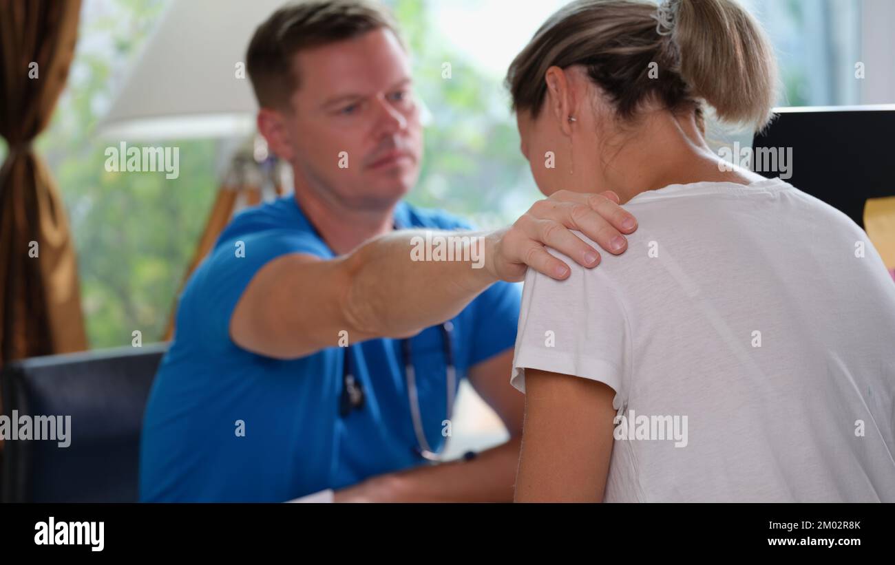 Il medico di sesso maschile rassicura la paziente di sesso femminile con una cattiva diagnosi. Foto Stock