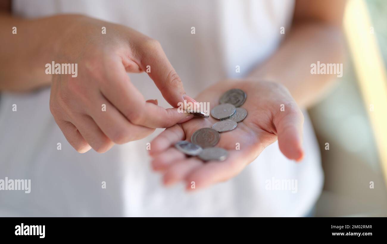 Donna che conta le monete nelle sue mani primo piano. Foto Stock