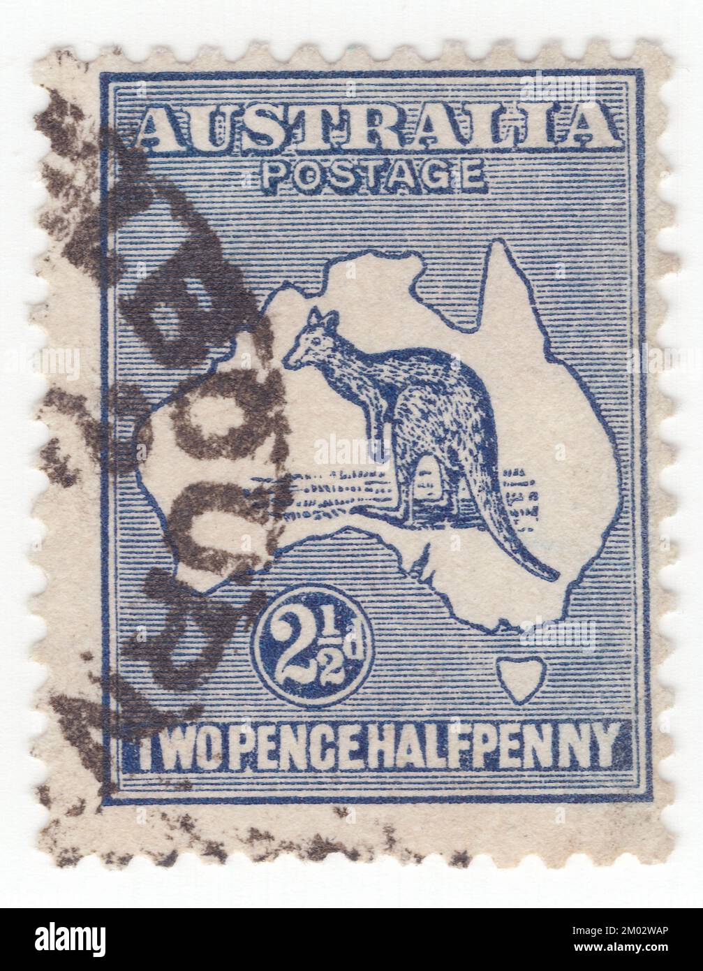 AUSTRALIA — 1913: Un francobollo blu scuro con recinzioni di 2½ che raffigura il canguro e la mappa dell'Australia. L'Australia è il continente abitato più antico, più flattoso e più arido, con i terreni meno fertili. È un paese megadiverso, e le sue dimensioni gli danno un'ampia varietà di paesaggi e climi, con deserti al centro, foreste pluviali tropicali nel nord-est e catene montuose nel sud-est. Il canguro è un simbolo riconoscibile dell'Australia. Prima emissione di francobolli australiani. Il canguro e l'emu sono presenti sullo stemma australiano Foto Stock