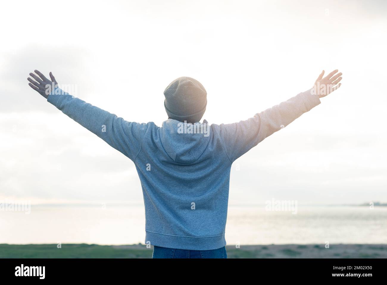 vista posteriore di una persona con le braccia sollevate al sole. Vacanza, concetto di vacanza. Foto Stock