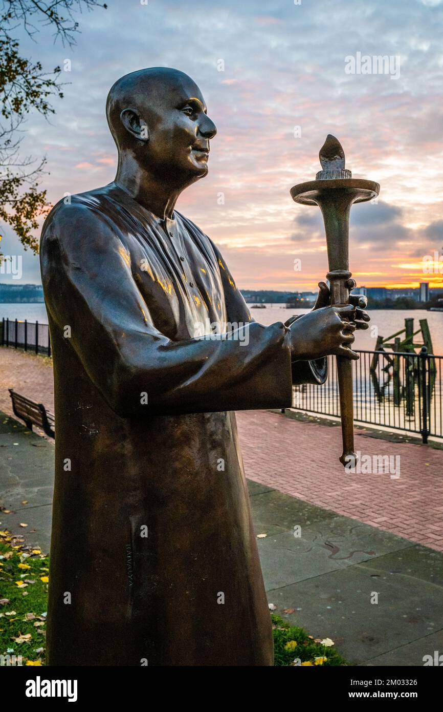 Statua dell'armonia mondiale della pace nella baia di Cardiff al tramonto. Primo piano della statua con sfondo acqua e tramonto. Foto Stock