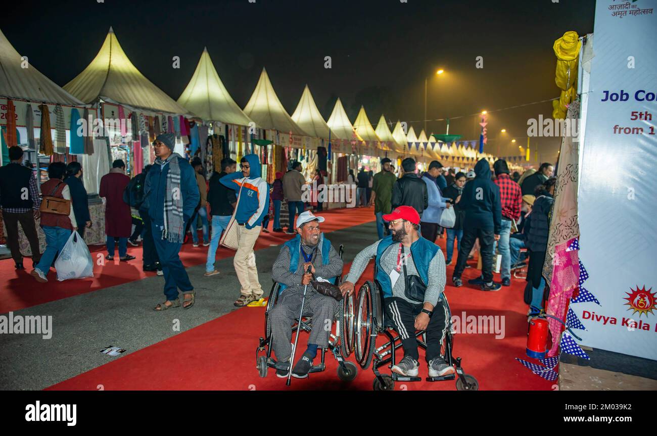 Gli espositori di scialle di pashmina seduti in sedia a rotelle L-R Farooq Ahmed Mir e Shabir Ahmad Wani del Kashmir parlano durante la Divya Kala Mela (fiera degli artigiani/artisti e imprenditori disabili) 2022 organizzata dal Governo indiano e dal NCPEDP (Centro Nazionale per la promozione dell'occupazione per le persone disabili) nella Giornata Mondiale della disabilità. NCPEDP è un'organizzazione volontaria senza scopo di lucro che funge da interfaccia tra il governo, l'industria, le agenzie internazionali e il settore del volontariato per l'empowerment delle persone con disabilità. Foto Stock