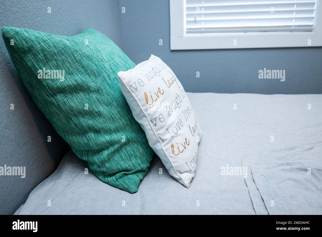 Una camera grigia con un comodo letto queen size Foto Stock