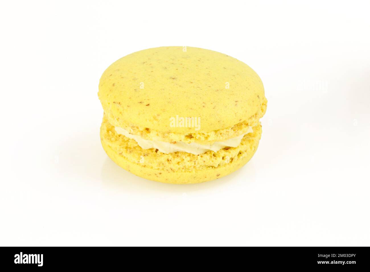 Macarone giallo singolo con crema ripieno bianca isolata su fondo bianco. Delicatezza al macaron francese Foto Stock