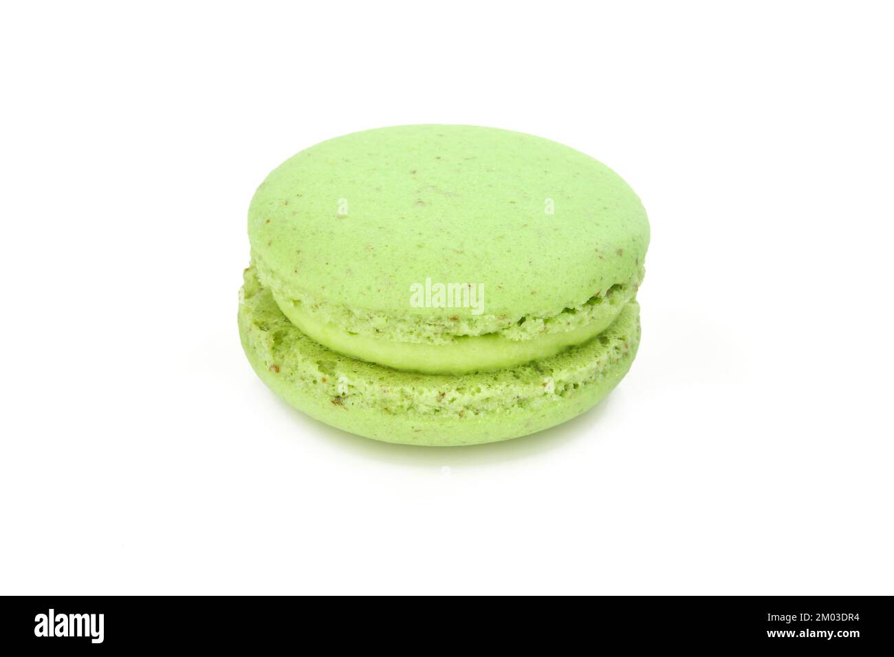 Macarone verde singolo con crema di riempimento verde isolato su fondo bianco. Delicatezza al macaron francese Foto Stock