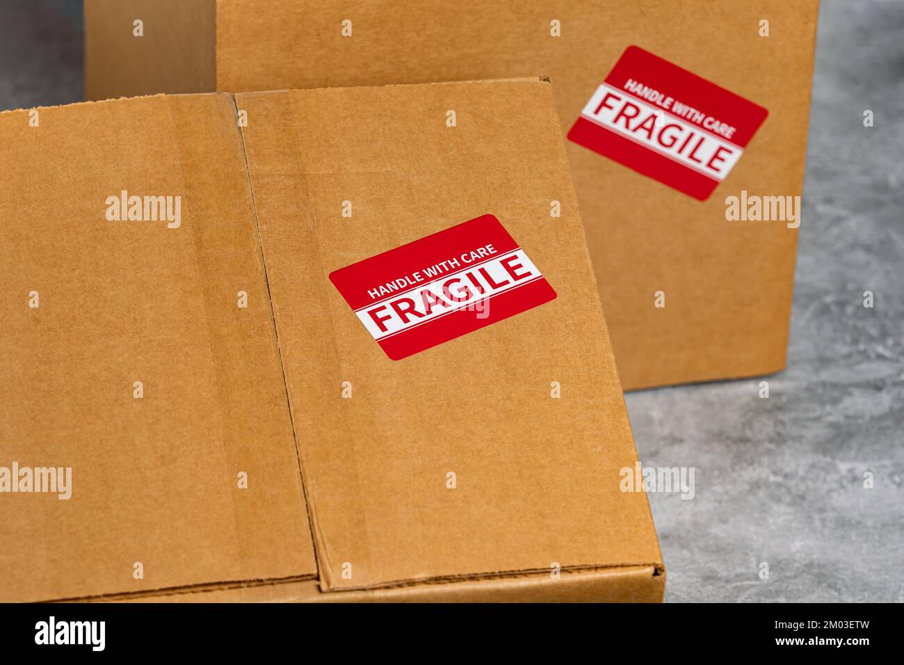 Scatola di cartone con etichetta fragile. Concetto di assicurazione pacco, consegna posta e termine di spedizione. Foto Stock