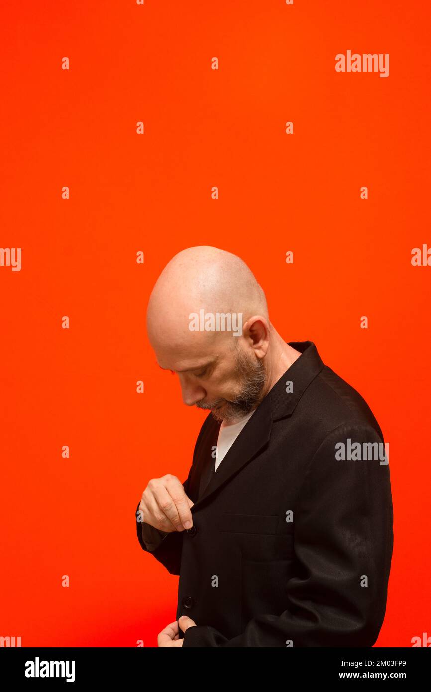 Uomo d'affari, di successo, elegante, calvo e bearded. Isolato su sfondo arancione. Foto Stock
