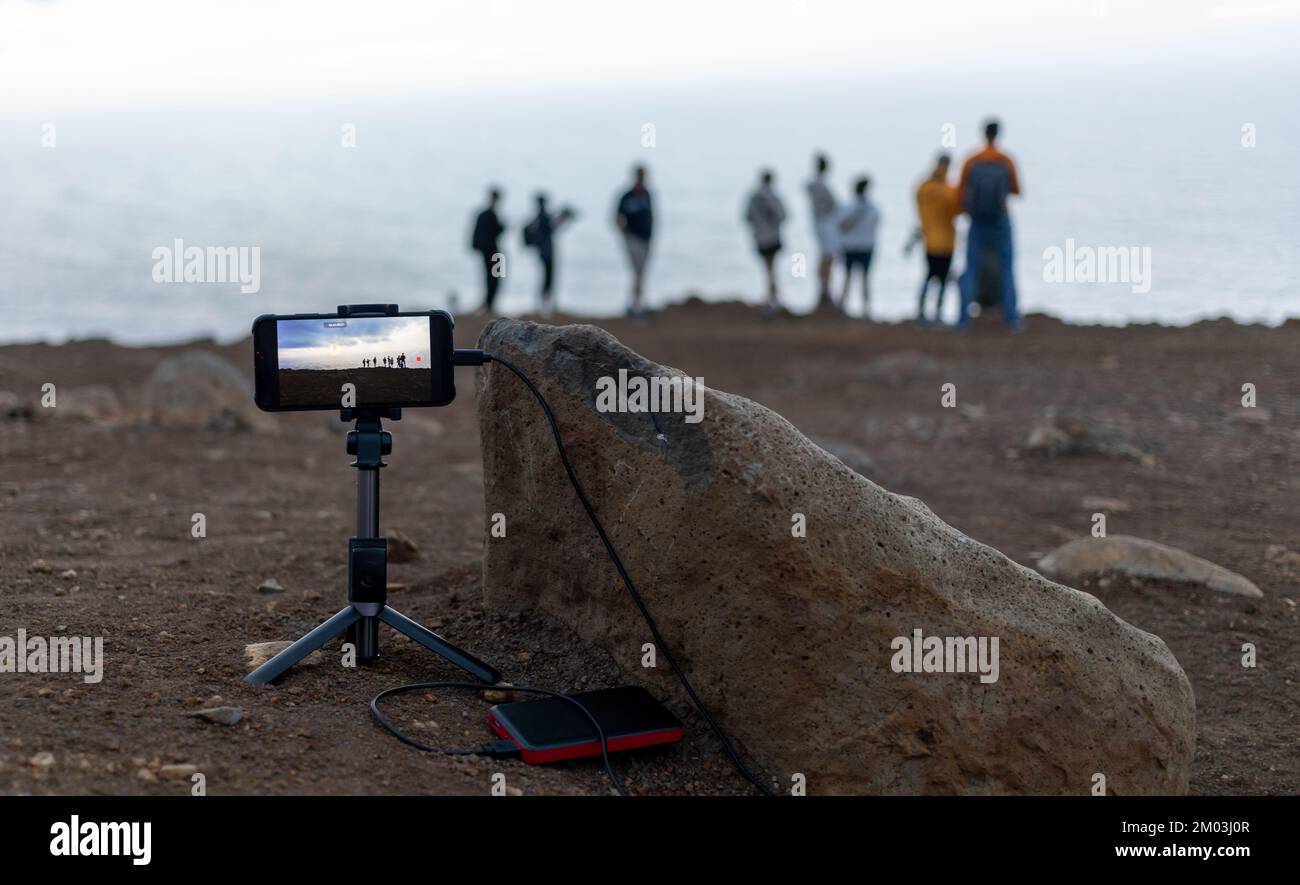 smartphone su cavalletto per scattare foto a un gruppo di persone durante le visite turistiche Foto Stock