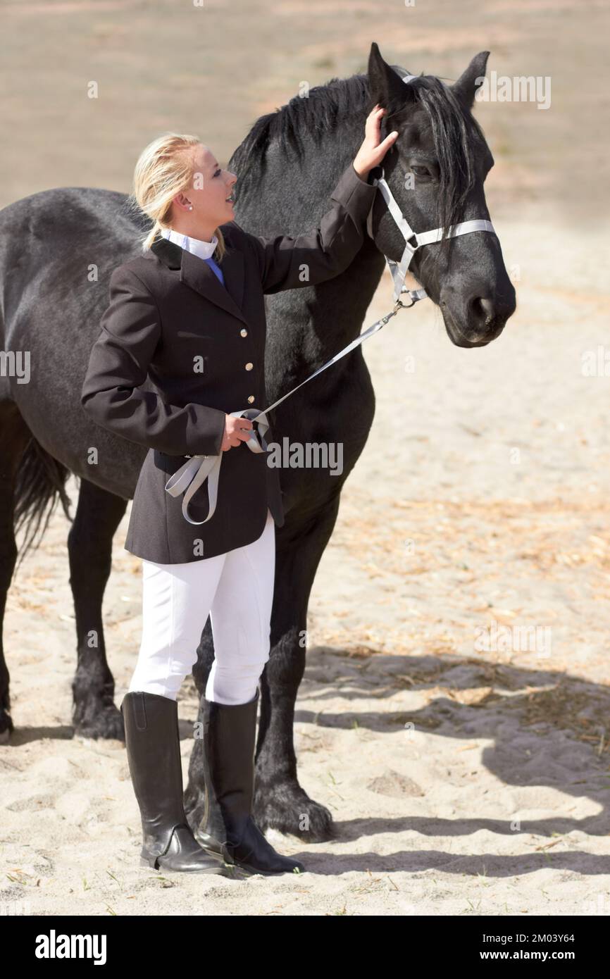 Un po' di attenzione va molto lontano. Colpo ad angolo alto di una giovane cavaliere femminile che accarezza il suo cavallo. Foto Stock