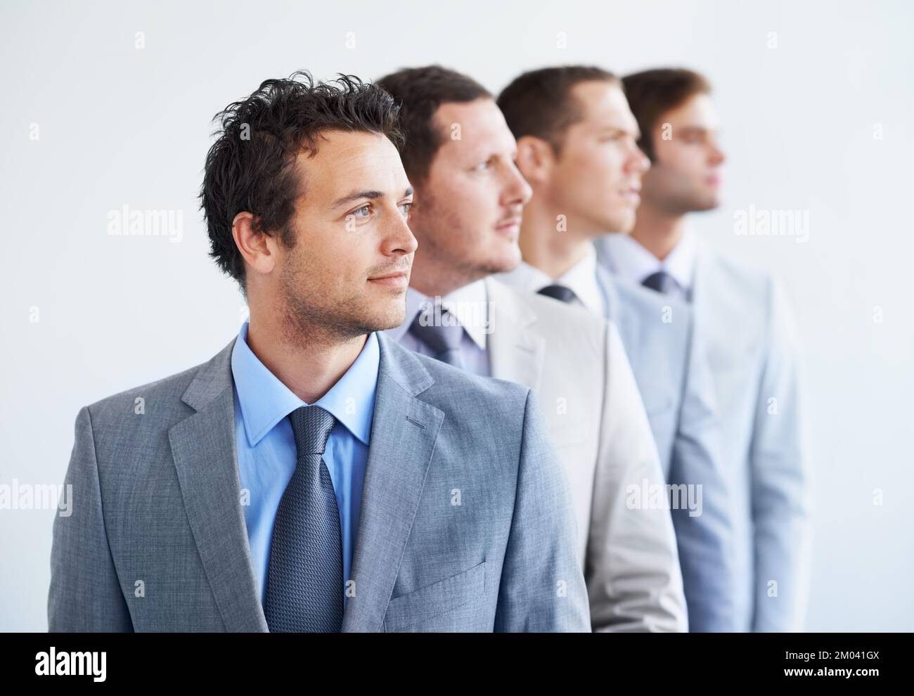 Ambizioso per il suo futuro aziendale. Una linea di uomini d'affari che guardano via con attenzione - ambizione. Foto Stock