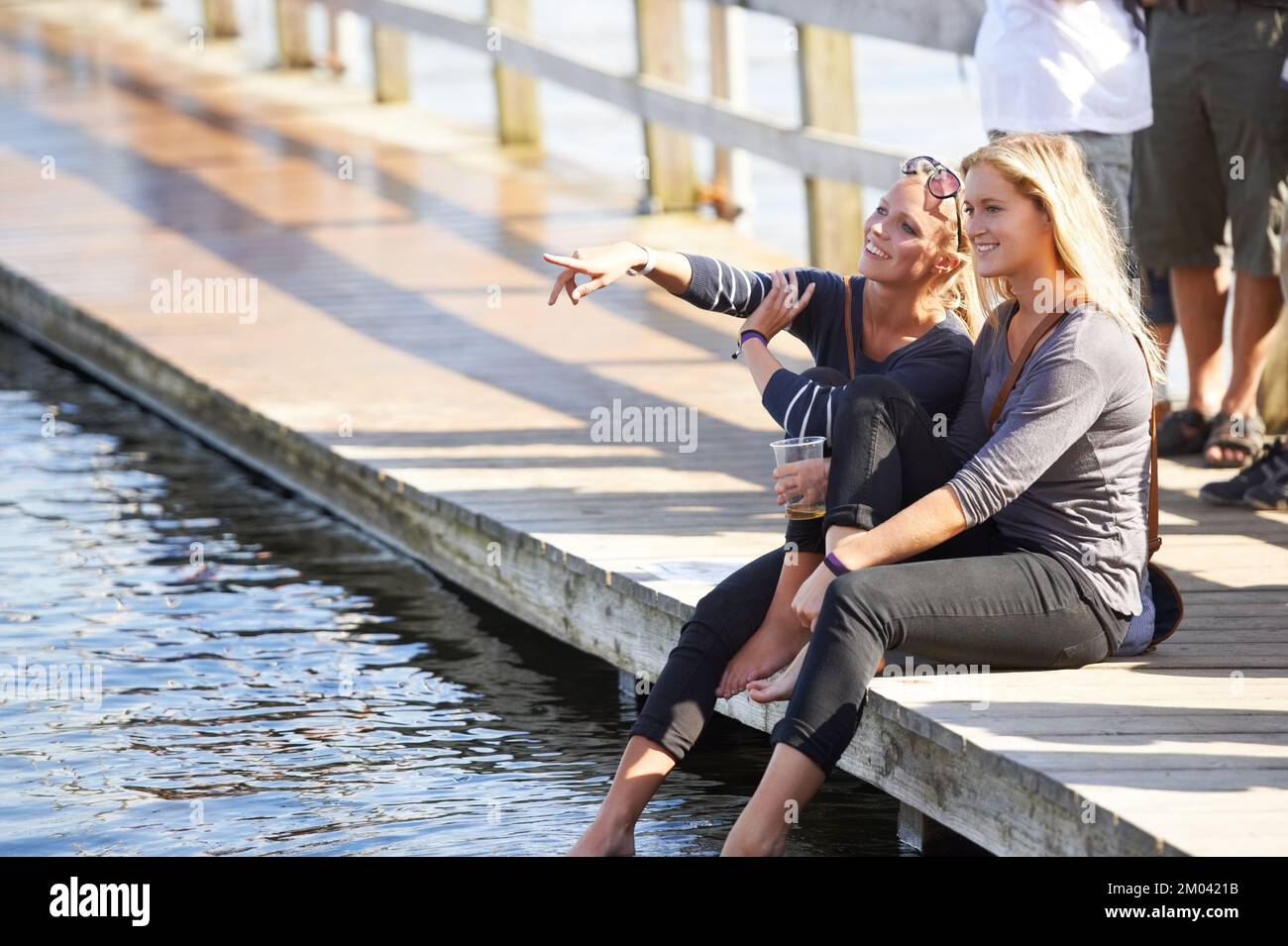 Che cosa è là sopra. due giovani donne che si rilassano in acqua in un festival all'aperto. Foto Stock