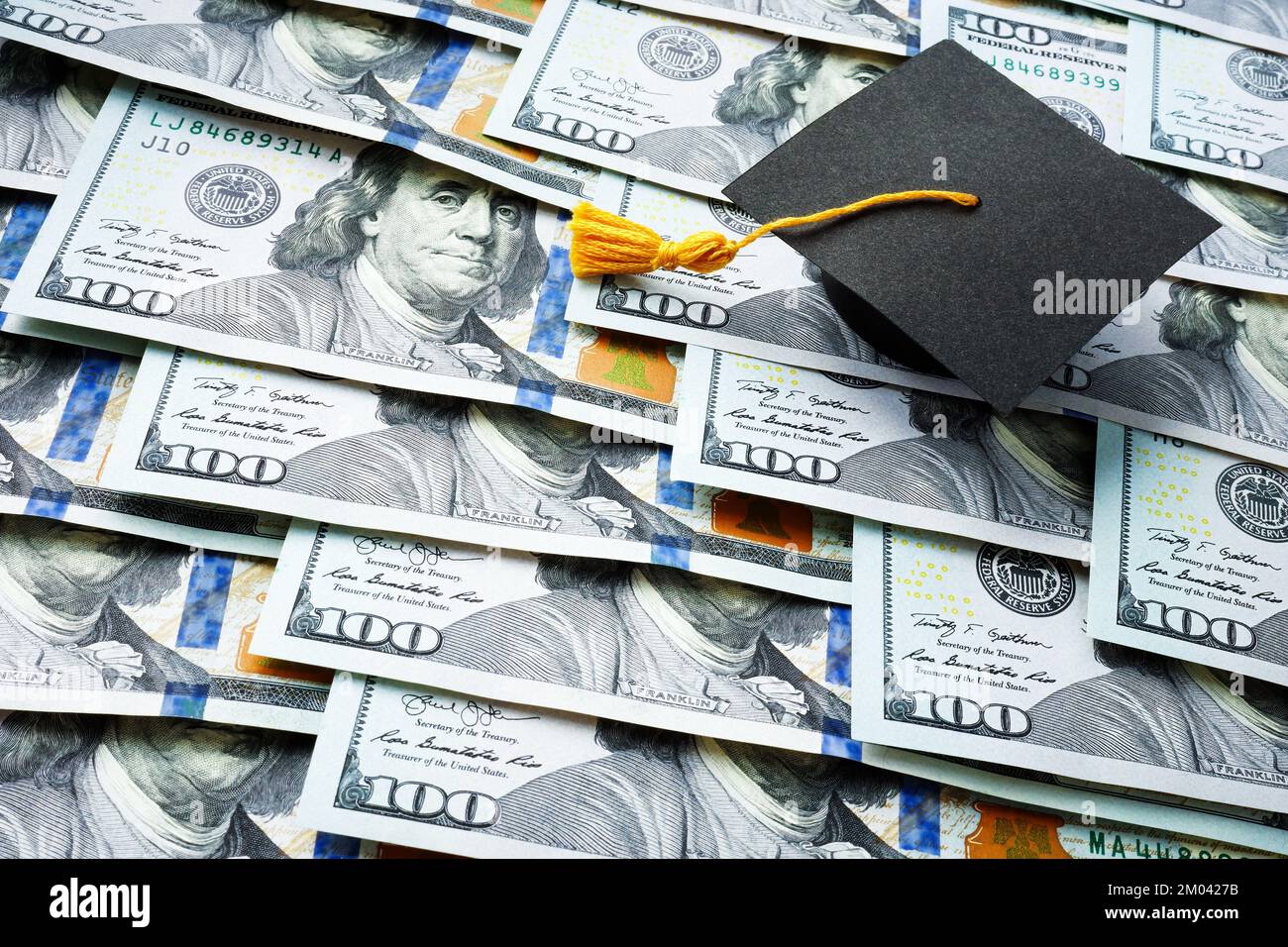 Tappo graduato sulla pila di denaro. Concetto di prestito per studenti. Foto Stock