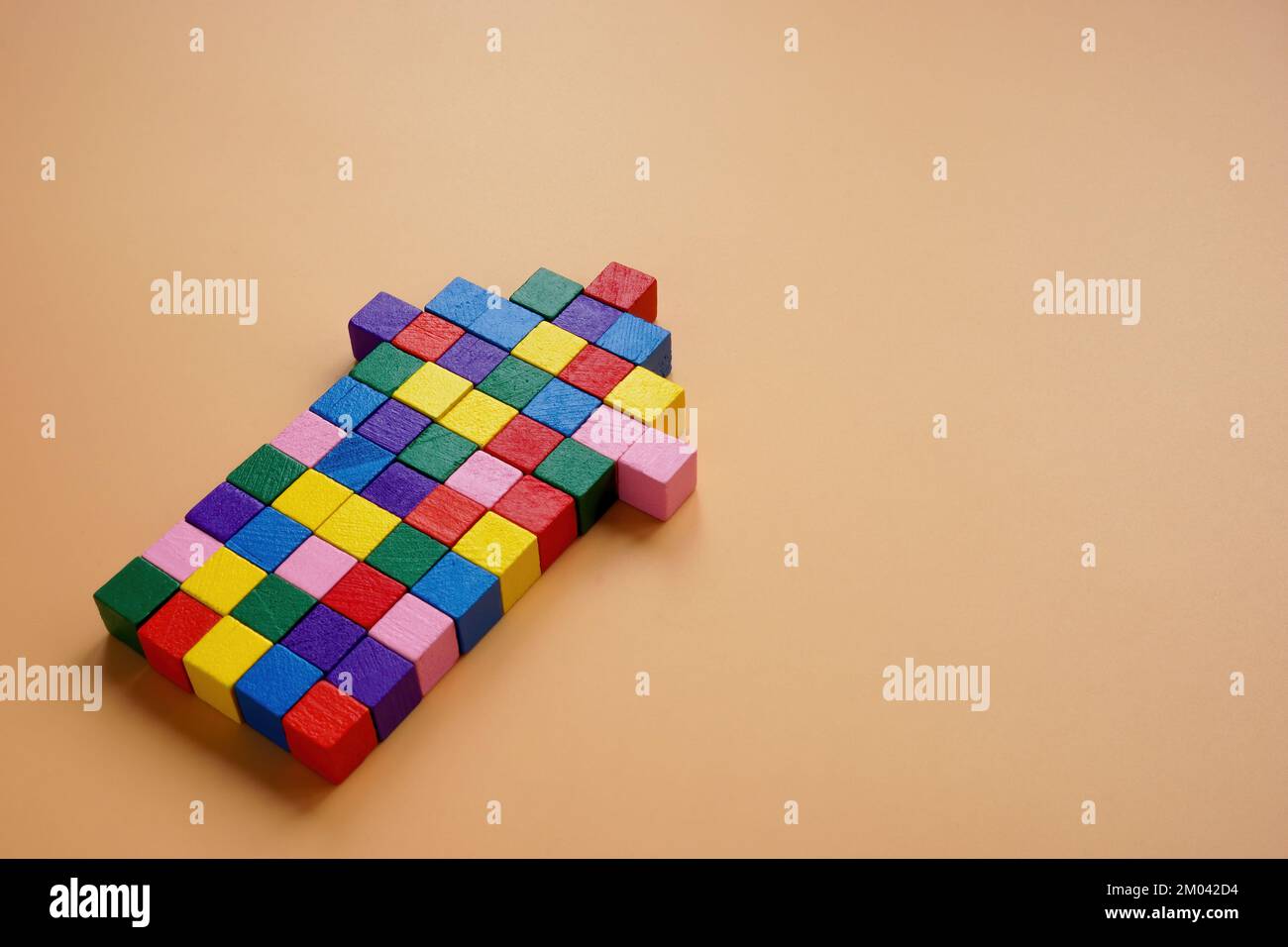 Una freccia di cubi multicolore come simbolo di unità, cooperazione e lavoro di squadra. Foto Stock