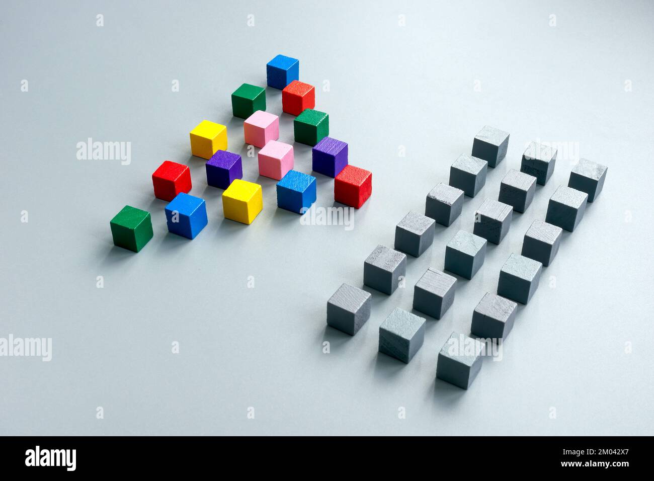 Linee di cubi grigi e una piramide multicolore come concetto di diversità. Foto Stock