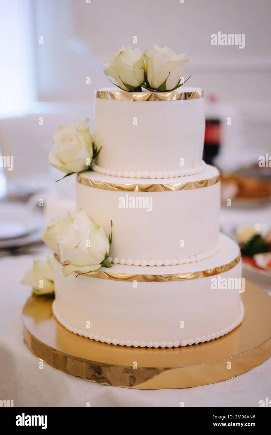 Una bella torta nuziale al ristorante. Torta decorata da fiori bianchi Foto Stock