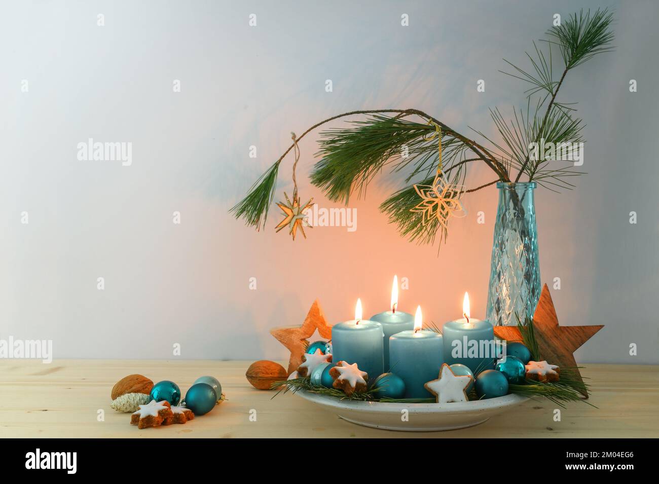 Quattro candele blu turchese per l'Avvento, decorazione natalizia, stelle in legno su un piatto e un vaso con rami di pino, spazio copia, fuoco selezionato, narro Foto Stock