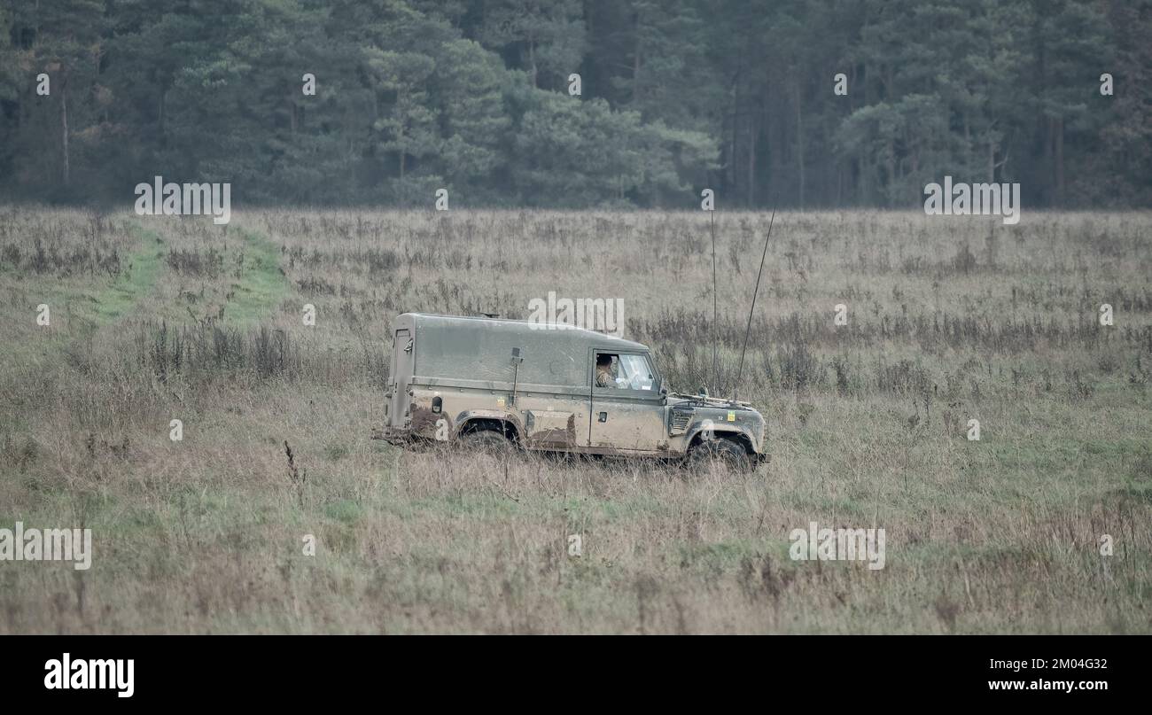 Esercito britannico Land Rover Defender veicolo di servizio leggero Wolf che si muove lungo una pista di fango su un esercizio militare, Wiltshire UK Foto Stock