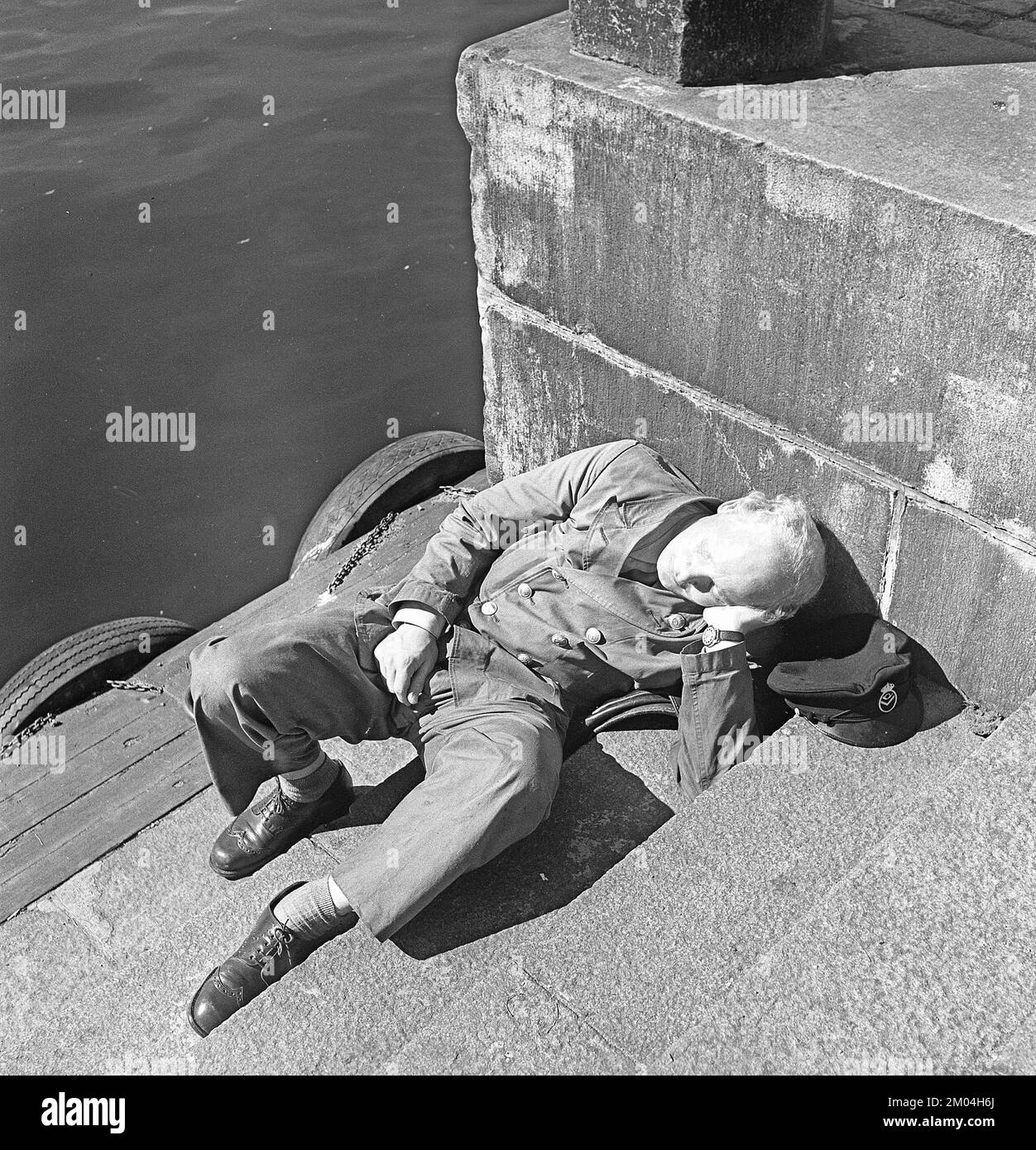 Avere un pisolino negli anni '1940s. Un mailman stanco sta avendo un pisolino all'aperto. Svezia 1949. Rif. Kristoffersson AS18-1 Foto Stock