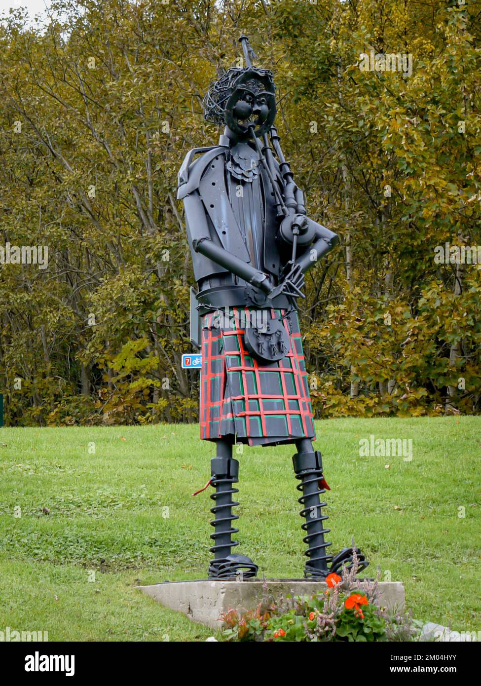 Drummond Hill, Tay Forest Park, Scozia il 13 ottobre 2009. Scultura metallica di uomo che gioca cornamusa indossando un forno rosso. Foto Stock