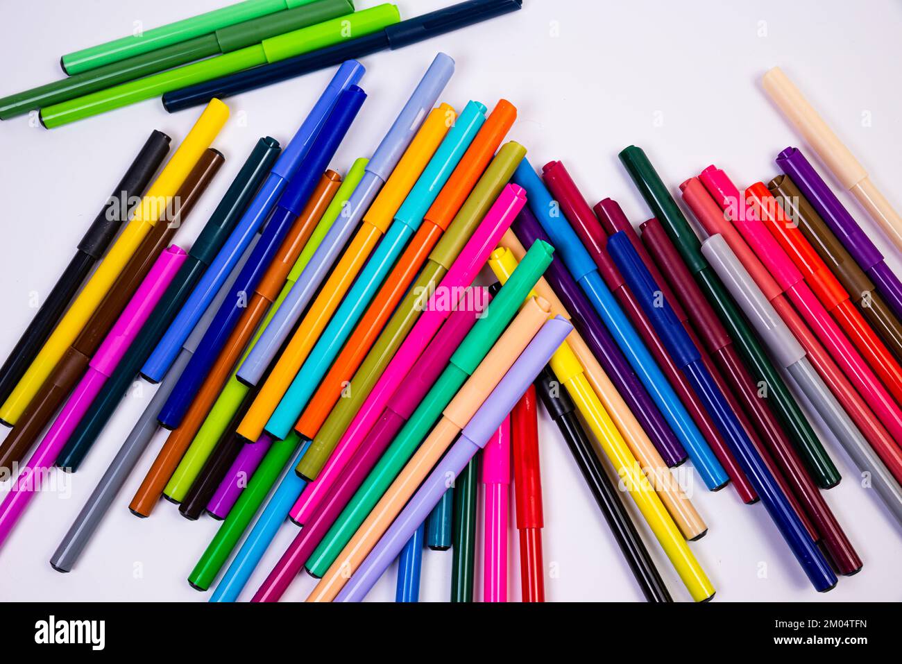Un set di penne multicolore in fila, arcobaleno su uno sfondo bianco chiaro per striscioni. Tracciatura di marcatori, matite, inchiostro, strumenti per artisti, creat Foto Stock