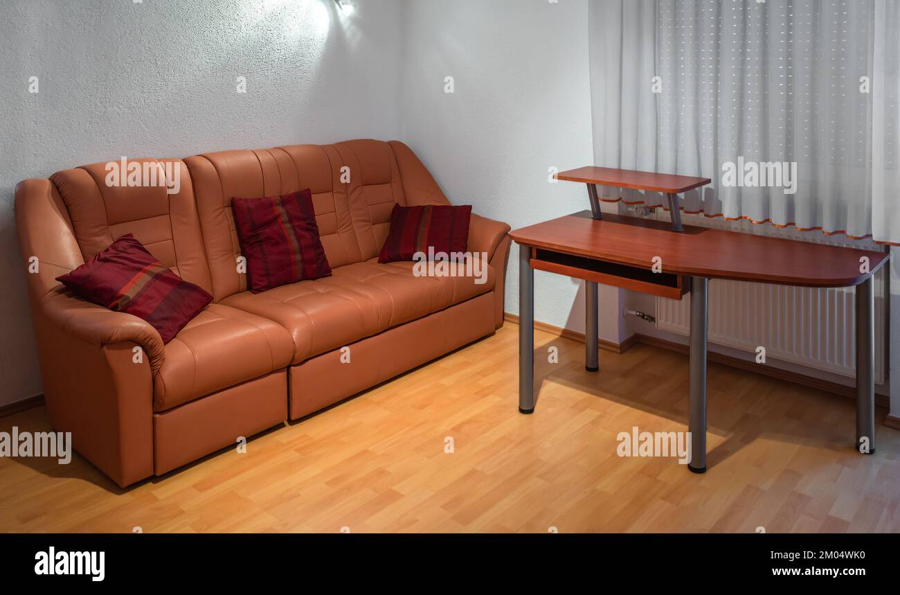 Il soggiorno dell''appartamento presenta un lussuoso divano in pelle e una scrivania Foto Stock