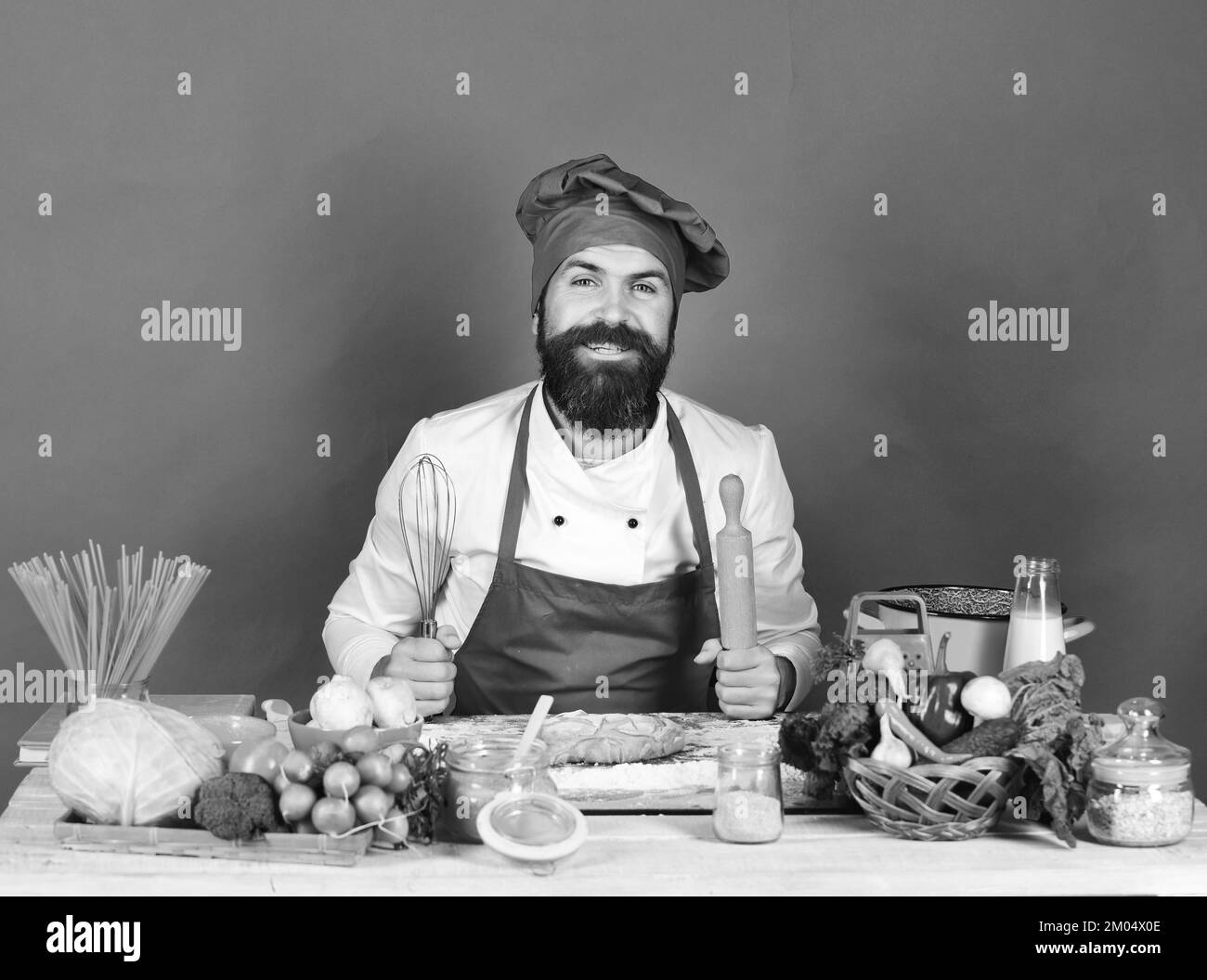 Concetto di cibo fatto in casa. L'uomo con barba si siede sul piano di appoggio Foto Stock