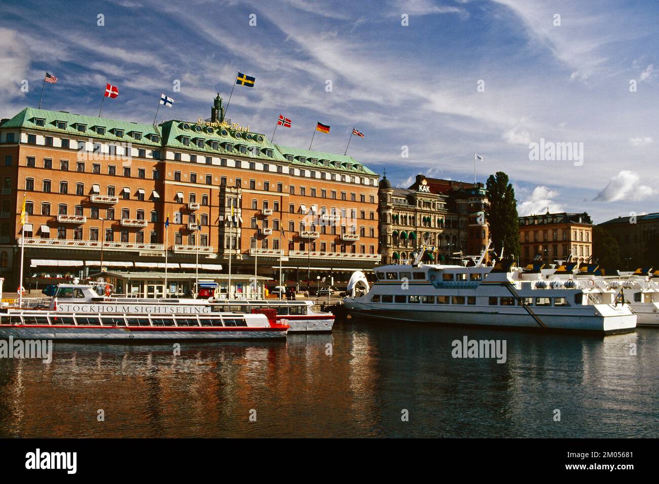Svezia. Stoccolma. Grand Hotel & tour boat ormeggiati sul lungomare. Foto Stock